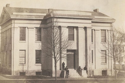 vintage sepia image of a large stately stone building on a lawn