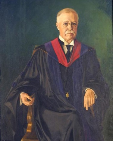 seated portrait of an older man in black doctoral robes with red and purple stole