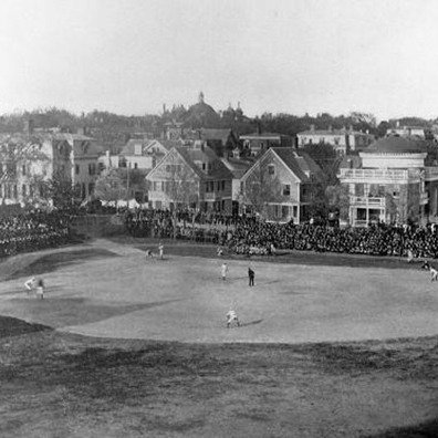 A black and white photograph of Brown's athletic field, with athletics positioned across the field and the audience on each side.